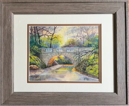 Framed painting of a stone bridge over a creek