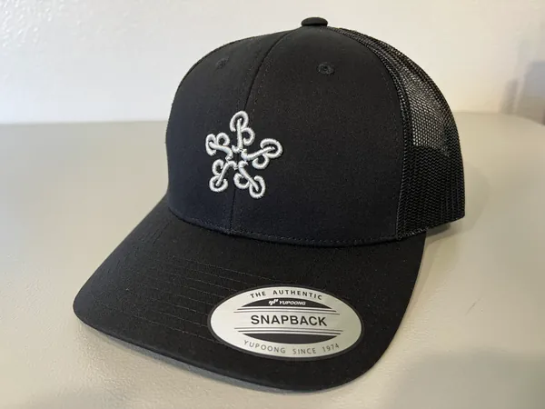 Black mesh-back trucker cap with a white raised-embroidery monogram of five looped B letters in a star shape