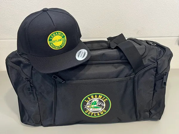 Black cap with a Laramie Outlaws Hockey Club patch, on a black duffel bag with the Laramie Outlaws logo