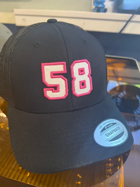 Black trucker cap with the number 58 in white twill edged in pink