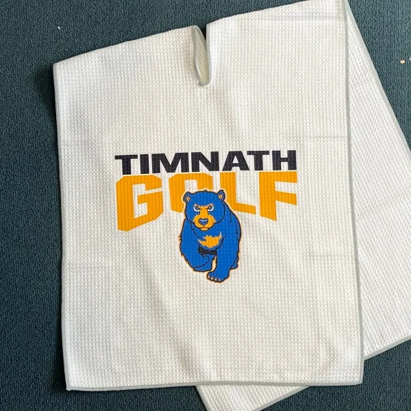 White golf towel printed with the Timnath Golf logo and a bear
